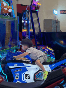 a young boy is riding a motorcycle with the number 88 on the side