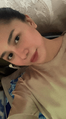 a woman is laying on a bed and taking a selfie with her phone
