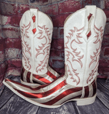 a pair of red white and silver cowboy boots on a wooden surface