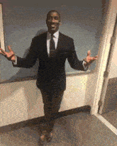 a man in a suit and tie with his arms outstretched