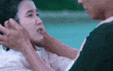 a man touches a woman 's face with his hands
