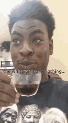 a man drinking a cup of coffee with the words " the white girls are fighting " on the bottom