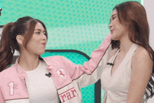 two women are standing next to each other and one is wearing a jacket that says rar on it