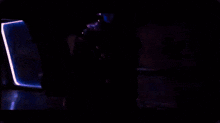 a dark room with a blue light coming out of the door