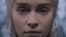 a close up of a woman 's face with blonde hair and blue eyes