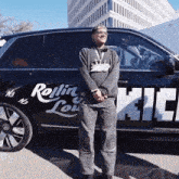 a man stands in front of a car that says rolling louie