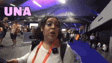a woman is standing in a crowded room with the word una above her