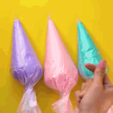 purple frosting is being poured on a yellow cake on a wooden cutting board