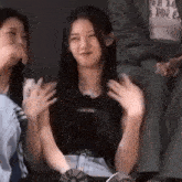 a group of women are sitting next to each other on a couch and applauding .
