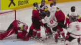 a group of hockey players are playing on a rink with a bank ad in the background .