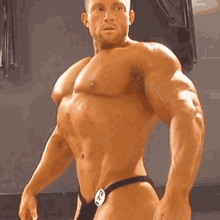 a shirtless man in a thong is standing in front of a window .