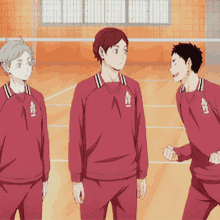 a group of boys are standing in a gym wearing red uniforms with the letters aei on the front