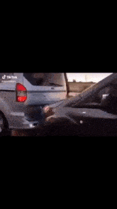 a silver car and a black car are driving next to each other
