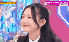 a girl is smiling in front of a sign that says 2024 on it