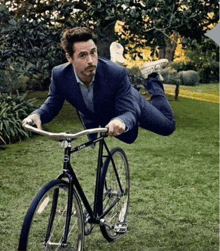 a man in a suit is riding a bicycle that says lynx