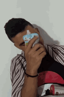 a young man is holding a packet of yogurt in his hand