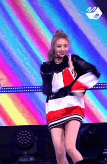 a woman in a red white and black striped dress is dancing on a stage
