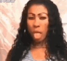 a woman with long black hair is making a funny face and looking at the camera .