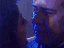 a man and woman are kissing in a dark room