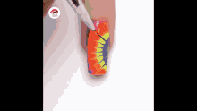a woman is painting a colorful design on her nails .