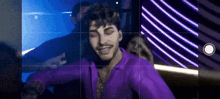 a man in a purple shirt is taking a picture of himself