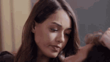 a close up of a woman kissing a man 's forehead