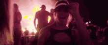 a woman is dancing at a music festival in front of a crowd .