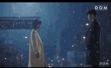 a man and a woman are standing next to each other holding hands in the snow .