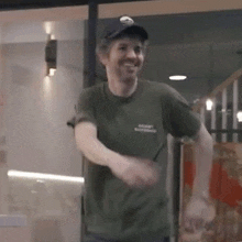a man wearing a hat and a green t-shirt is dancing .