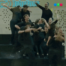 a group of people are dancing in front of a john fools sign