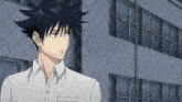 a man with black hair and a white shirt stands in front of a building