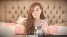 a woman is sitting on a bed with her hand up and says `` because you are good as you are `` .