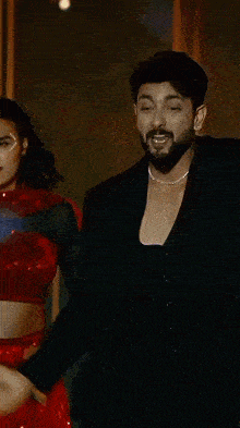 a man with a beard is wearing a black jacket and a choker