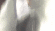 a blurry picture of a person 's torso in a suit and tie .