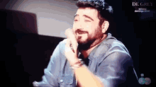 a man with a beard is on a television screen with the word de grey on the bottom
