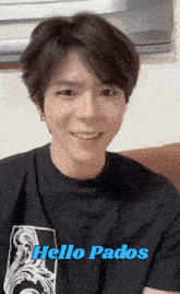 a man wearing a black shirt with the words hello pados on it