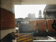a person holding a gun in front of a train that says n on it