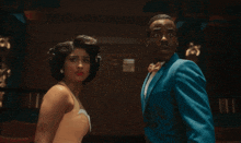 a man and a woman are standing next to each other and the woman is asking the man what