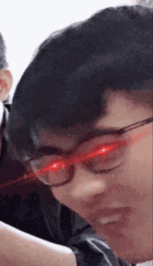 a close up of a person 's face with red eyes and glasses