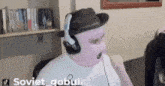 a man wearing a pink mask and headphones has the name soviet_gobul written on the bottom