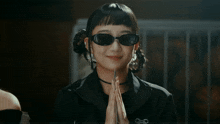 a woman wearing sunglasses and a choker with the letter g on it
