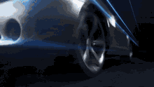 a close up of a car 's wheel with a blue light behind it