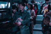 a group of people are sitting on a bus and one of them is smiling