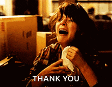 a woman is crying while holding a napkin in front of a box that says i love you