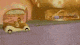 a cartoon car with the number 6 on the side is driving down a street .