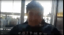 a man is sitting in front of a window on a video call with his eyes closed .