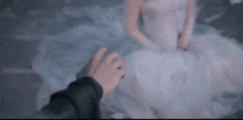 a man in a suit is holding the hand of a woman in a wedding dress