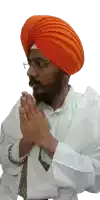 a man wearing an orange turban is praying with his hands together