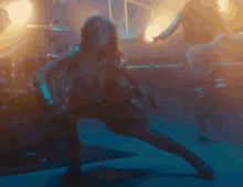 a woman with long hair is playing a guitar on a stage
