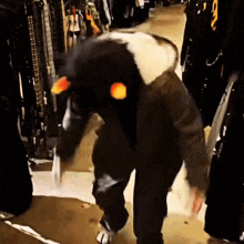 a person wearing a penguin costume is walking in a store